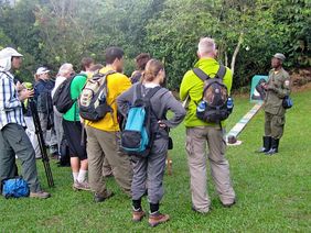 Ein Führer informiert eine Gruppe von Touristen vor dem Besuch der Bwindi-Gorillas über das richtige Verhalten.