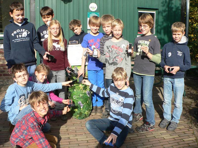 Juniorclub-Mitglieder füllen die ­Handy-Sammelbox in Krefeld